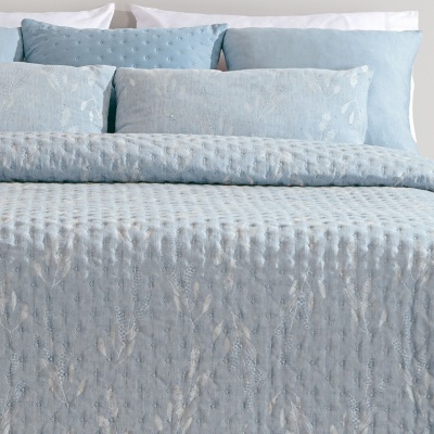 Conjunto de roupa de cama azul claro texturizado com almofadas em tons de azul e cinza