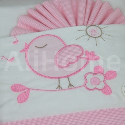 tecido branco e rosa com bordado de pássaro, flor e sol e padrão xadrez