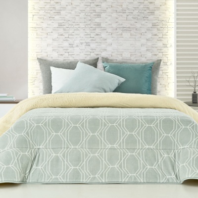 Cama com roupa de cama amarelo e verde claro, almofadas cinza e verde-azul, parede branca texturizada, mesas laterais com decoração