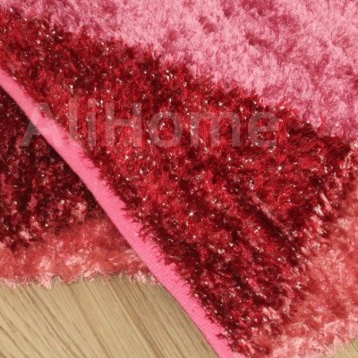 Tapete felpudo vermelho e rosa com palavra 'Home' sobre chão de madeira