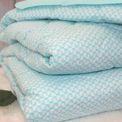 Conjunto de roupas de cama azuis e brancas dobradas com padrão de quadrados pequenos