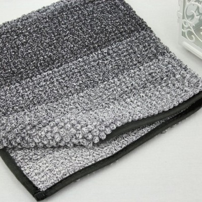 Toalha de banho cinzenta e preta com textura felpuda. 