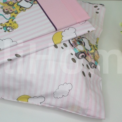 Lençóis de berço rosa com gatinhos e planta decorativa