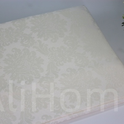 Toalha de mesa branca com padrão floral em relevo e vaso decorativo