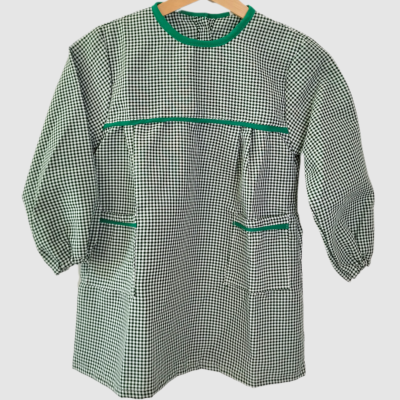 Casaco xadrez verde e branco com detalhes verdes pendurado num cabide