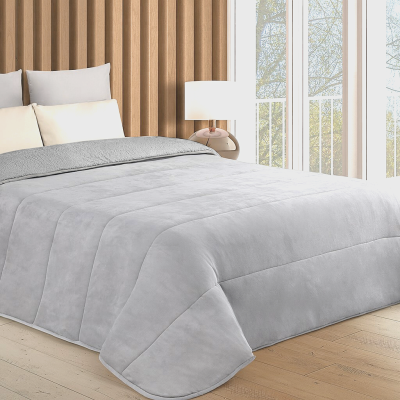 Edredão cinzento claro sobre cama com almofadas brancas no quarto com parede de madeira e janela