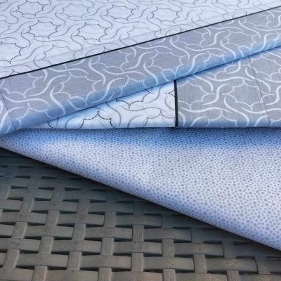 Tecido azul claro com padrões brancos sobre mesa de rattan preta