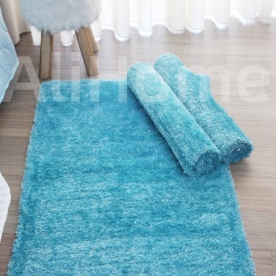 Tapete azul peludo ao lado de banco felpudo com vaso e planta