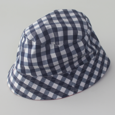 Chapéu pescador xadrez azul e branco sobre superfície branca