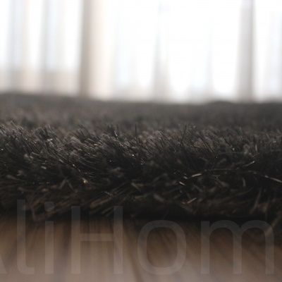 Tapete preto pelúcia sobre chão de madeira