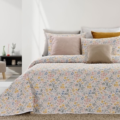 Conjunto de cama com edredão floral e almofadas em quarto minimalista