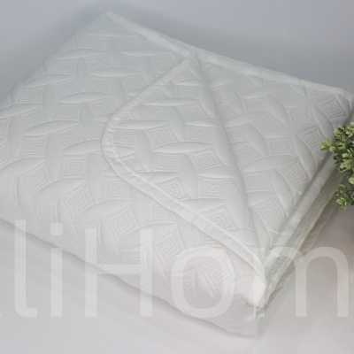 Capa branca para colchão com textura geométrica e planta em vaso dourado