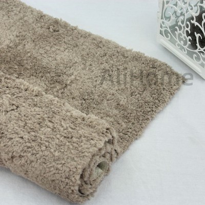 Tapete felpudo bege claro com lanterna decorativa branca ao lado