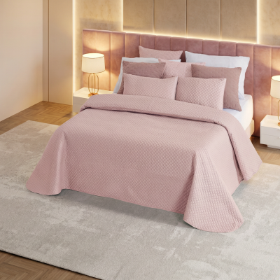 Cama de casal com roupa de cama rosa acolchoada em quarto moderno com cabeceira estofada rosa e luminárias ao lado.