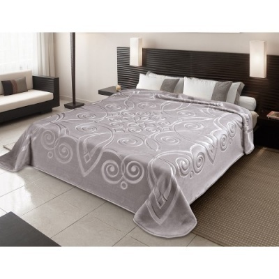 Cobertor cinzento com padrão arabescos em cama num quarto moderno