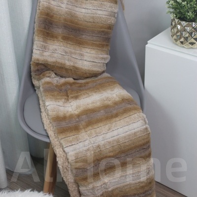 Manta felpuda listrada em tons castanhos sobre cadeira cinzenta