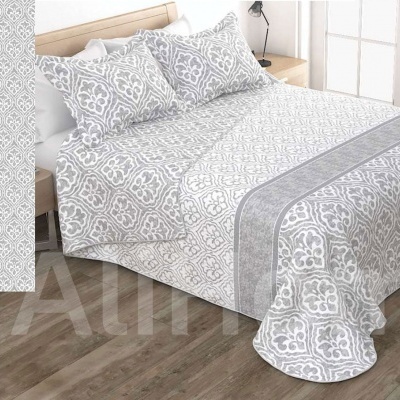 Conjunto de cama cinza e branco com padrão geométrico num quarto com chão de madeira clara