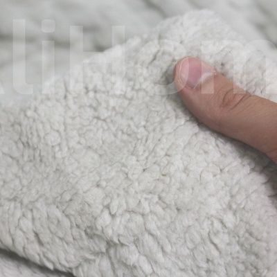Mão segurando tecido branco felpudo e macio