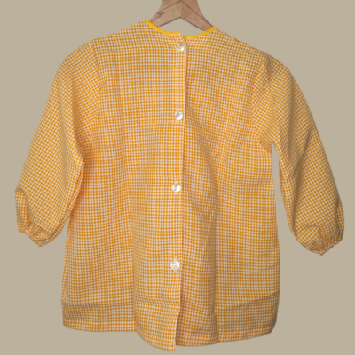 Camisa xadrez amarelo e branco com botões brancos na parte de trás