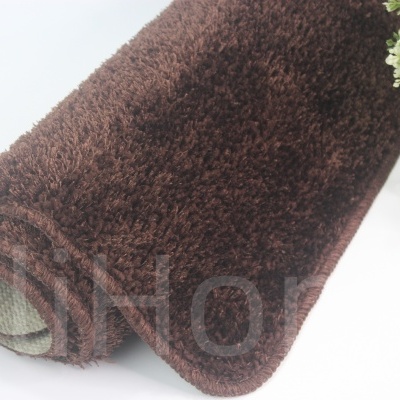 Tapete castanho escuro de pelo alto enrolado com vaso decorativo ao lado