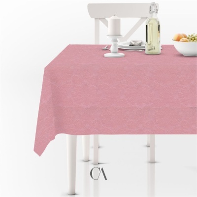 Toalha de mesa cor-de-rosa com padrão floral sutil num ambiente com móveis e acessórios em branco.