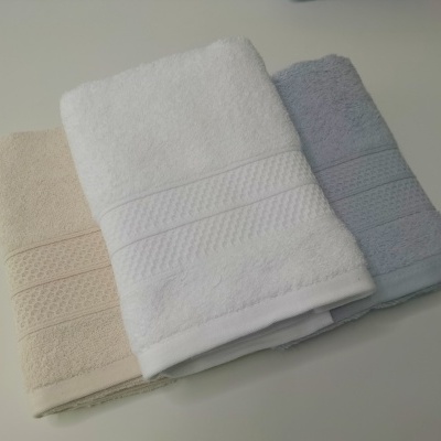 Três toalhas de algodão em bege, branco e cinza com padrão texturizado