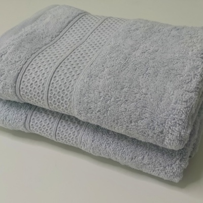 Toalhas cinza empilhadas com padrão trançado