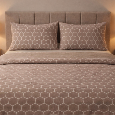 Cama estofada com roupa de cama padrão hexagonal e candeeiros em mesas de cabeceira