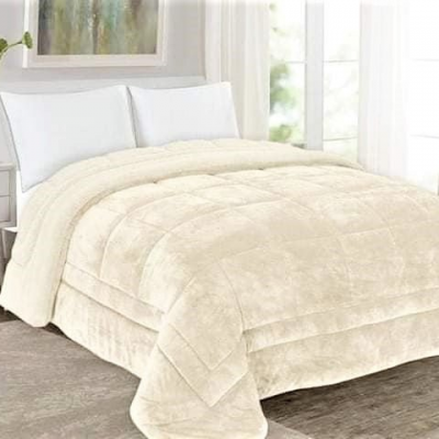 Colcha de cama beige macia com padrão quadrado e dois travesseiros brancos num quarto iluminado