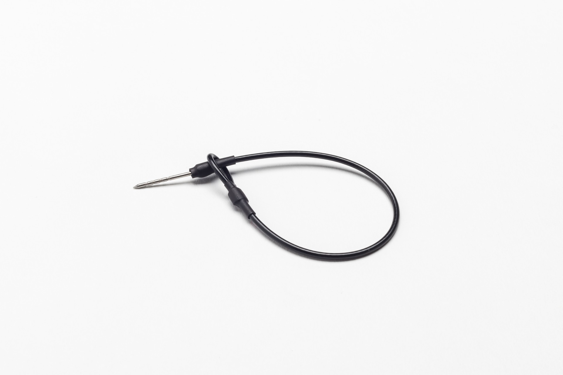 Cabo de termopar com conector metálico e cabo preto sobre fundo branco