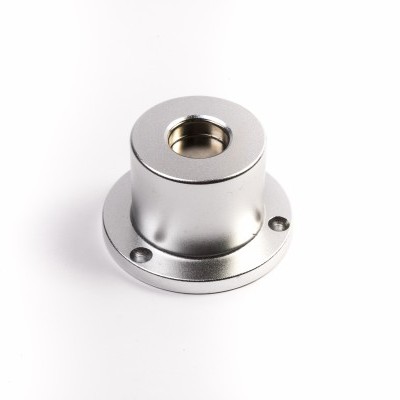 Peça metálica cilíndrica prateada com base circular e três furos para fixação