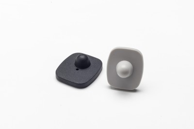 Dispositivos de segurança anti-roubo em plástico preto e branco sobre fundo branco