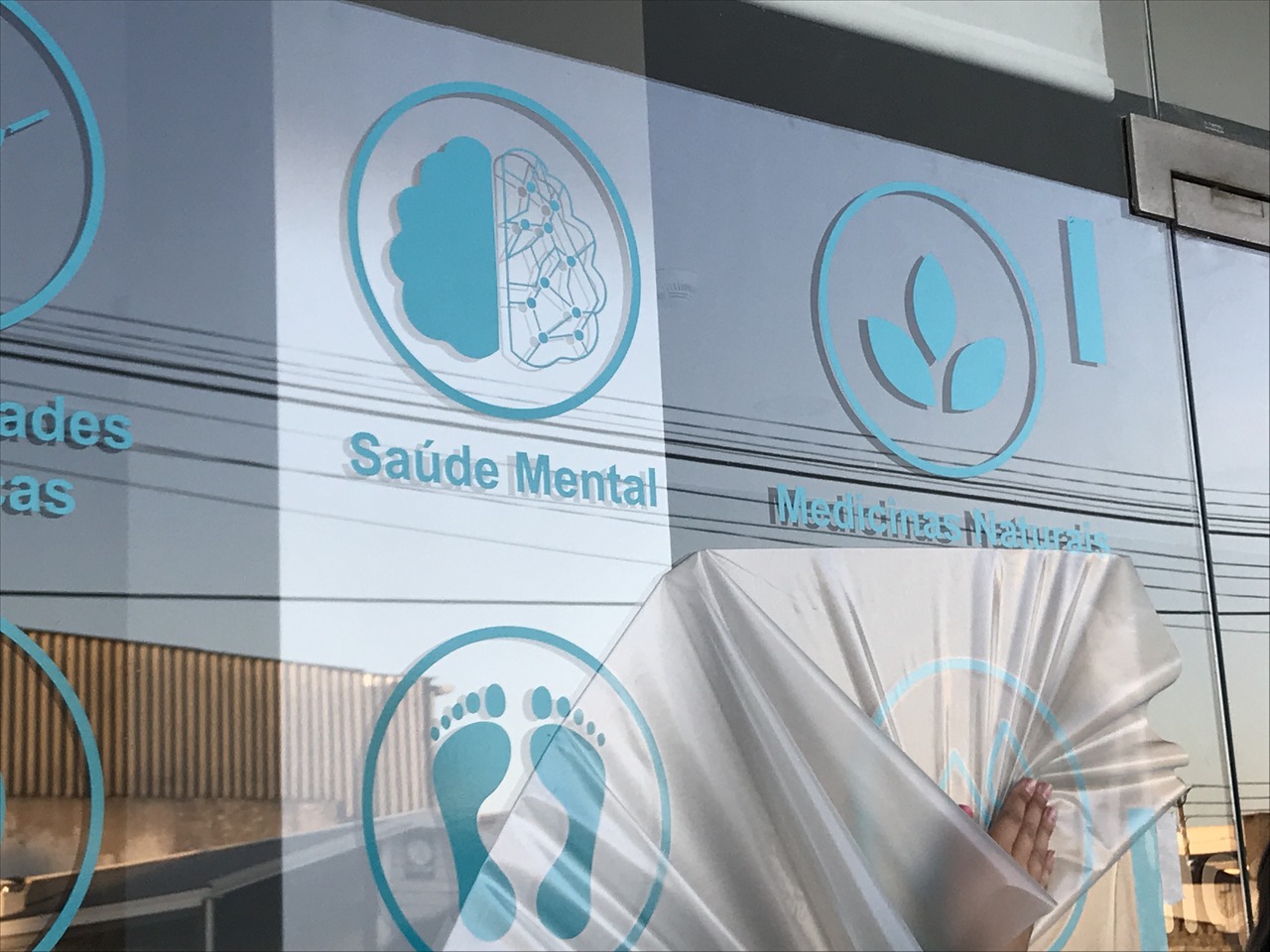 Reflexo em vidro com ícones azuis e texto sobre saúde mental e pegadas