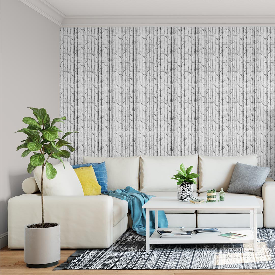 018 Sala com sofá branco, almofadas coloridas, mesa branca, planta, papel de parede geométrico cinzento.