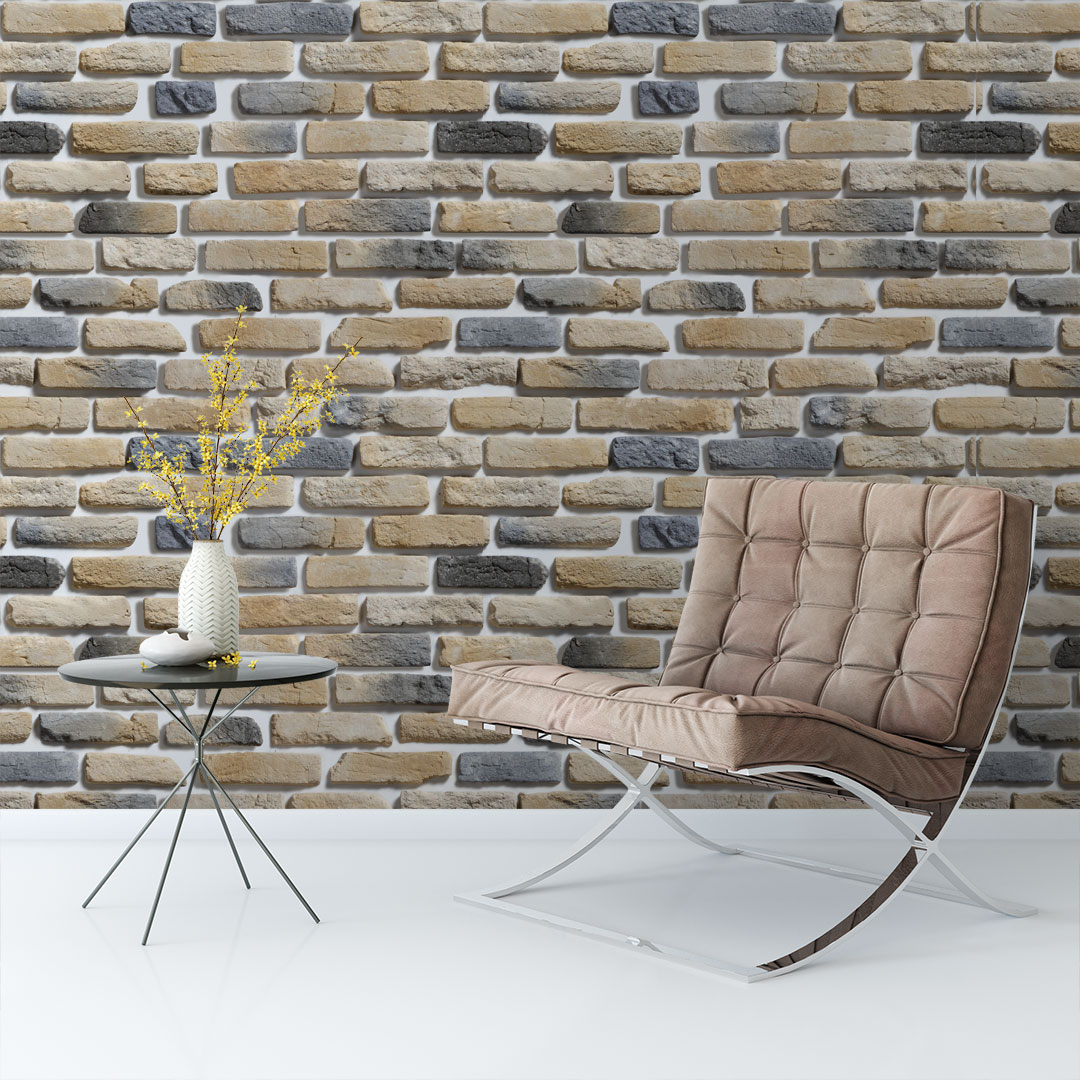 018 Cadeira estofada bege com mesa lateral preta e vaso branco com flores amarelas junto a parede de tijolos decorativos