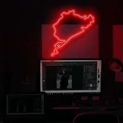Espaço de trabalho com monitor, mesa, microfone e luz de néon vermelha.