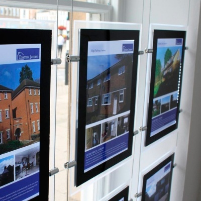 Painéis publicitários de imóveis à venda com o logo Thomas James