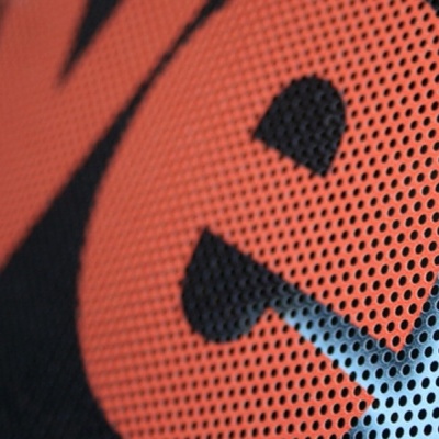 Detalhe de padrão de pontos laranja e azul em tecido preto