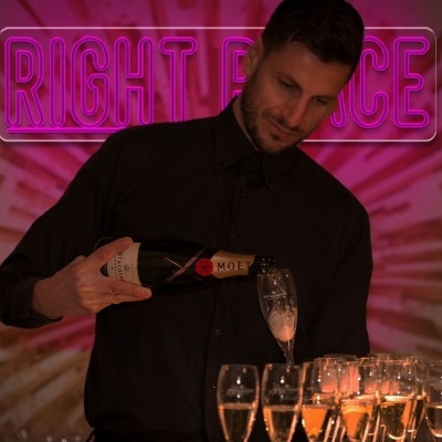 Homem a servir champanhe Moët & Chandon com letreiro de néon rosa