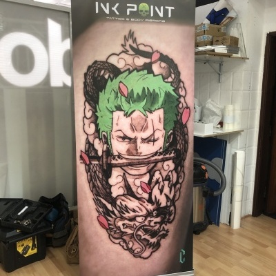 Banner vertical com imagem de tatuagem colorida de personagem com cabelo verde segurando espada e texto Ink Point Tattoo & Body Piercing