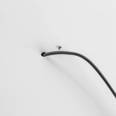 cabo preto passando por orifício em painel branco com parafuso