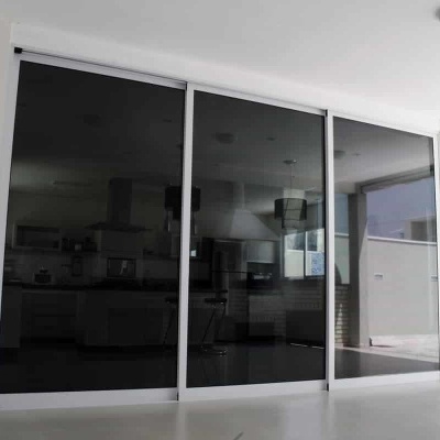 Porta de correr de vidro fumado com moldura branca em ambiente interior moderno