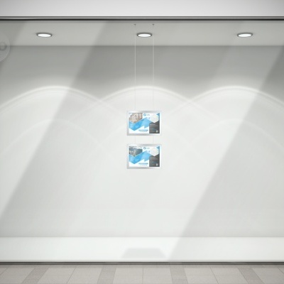 Montra branca minimalista com dois cartazes azuis suspensos iluminados por quatro luzes de teto