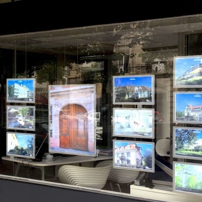 Mostruário com fotografias de imóveis em janela de loja