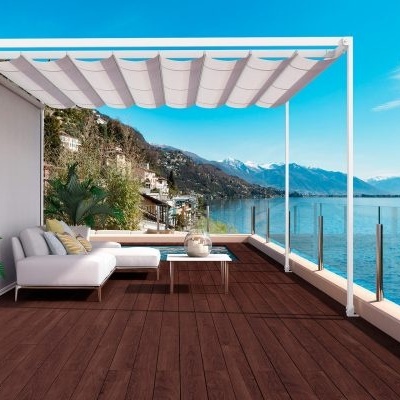 Varanda com cobertura branca, sofá branco, mesa, plantas, chão de madeira e vista para lago