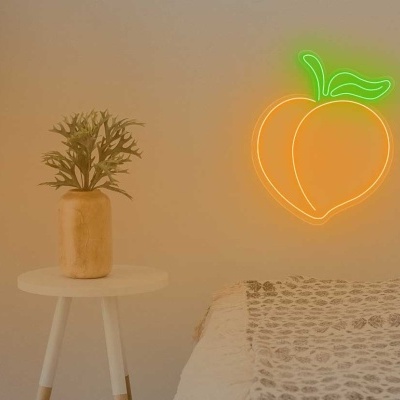 Sala com cadeira bege, manta malha, mesa com vaso e luminária neon pêssego