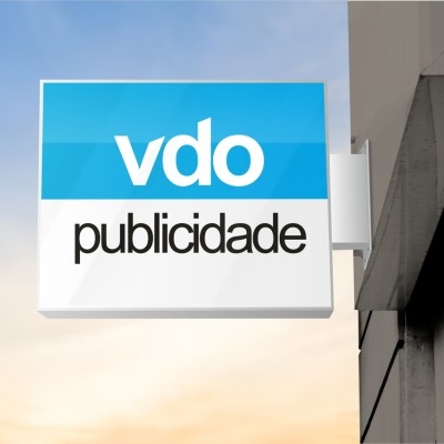 Letreiro azul e branco com texto 'vdo publicidade' numa parede de edifício