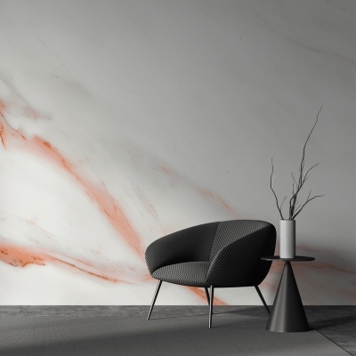 Cadeira preta texturizada com mesa lateral preta e vaso branco com ramos secos, parede com padrão marmorizado laranja