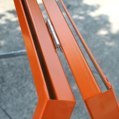 Estrutura metálica dobrável laranja com dobradiça em metal prateado