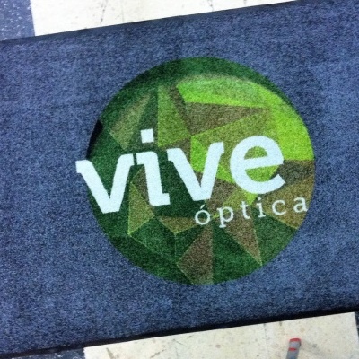 Tapete azul escuro com logótipo verde e texto 'vive óptica'